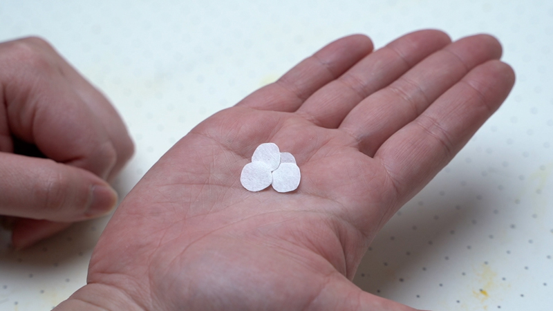 手のひらに乗った10mmくらいの円形の紙
